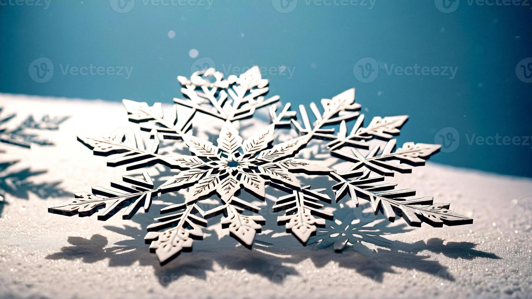 Stunning close up of intricate white snowflake ornament resting on sparkling snow with soft blue background creating magical winter atmosphere photo