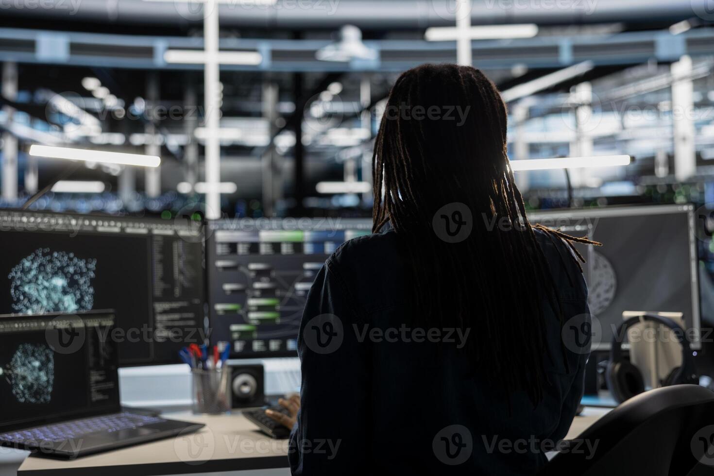 Data center technician uses AI visualization tool on computer to oversee automated repetitive tasks. Worker adapting server systems based on data analytics graphs using desktop PC photo