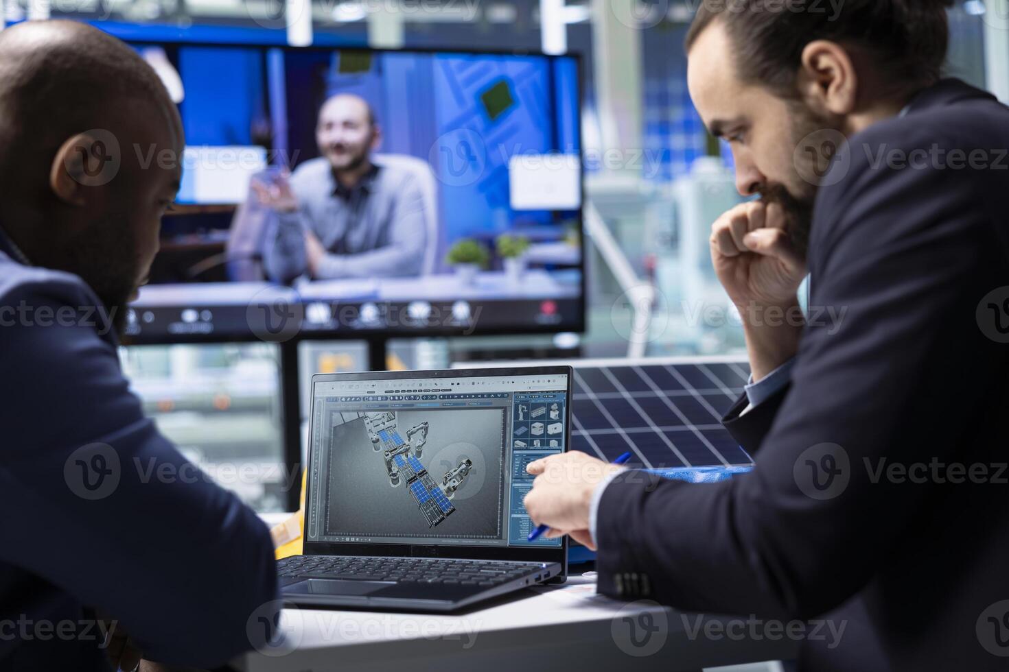 Photovoltaics factory experts designing production lines for solar panel assembly facility in CAD program during videocall, using simulation software to optimize factory production layouts photo