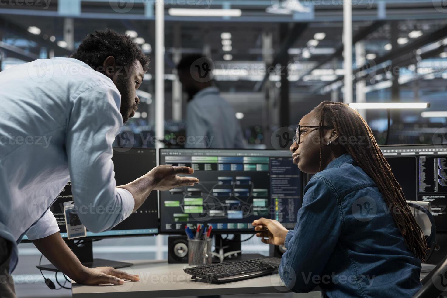 Data center software developers programming equipment used for machine learning training. Server room IT specialists talking, running code on PC to upgrade artificial intelligence systems photo