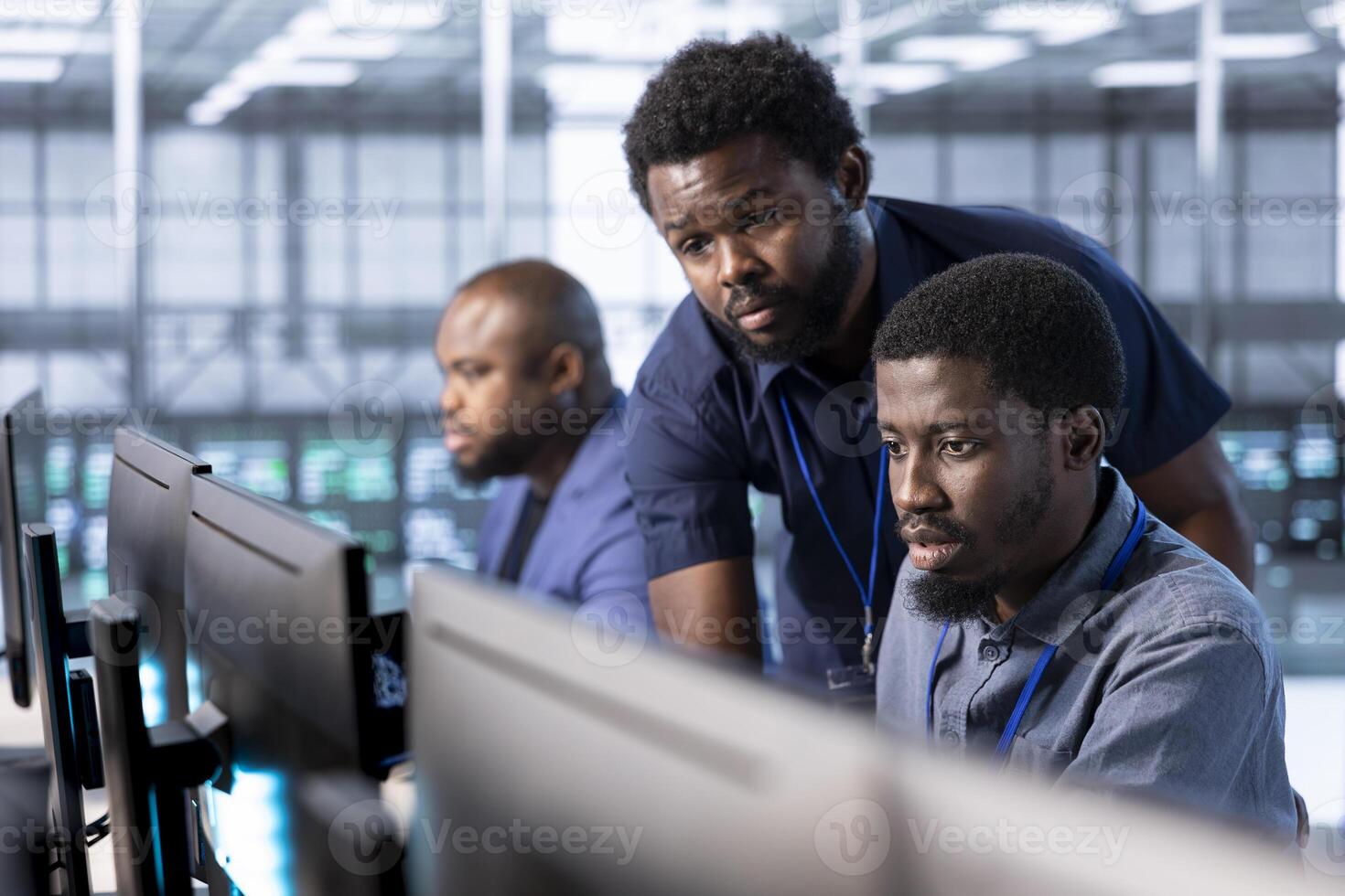 Manager in server hub overseeing workers using computer to find firewall misconfigurations affecting rackmounts. Supervisor checking systems bottlenecks leading to sluggish data transfer rates photo