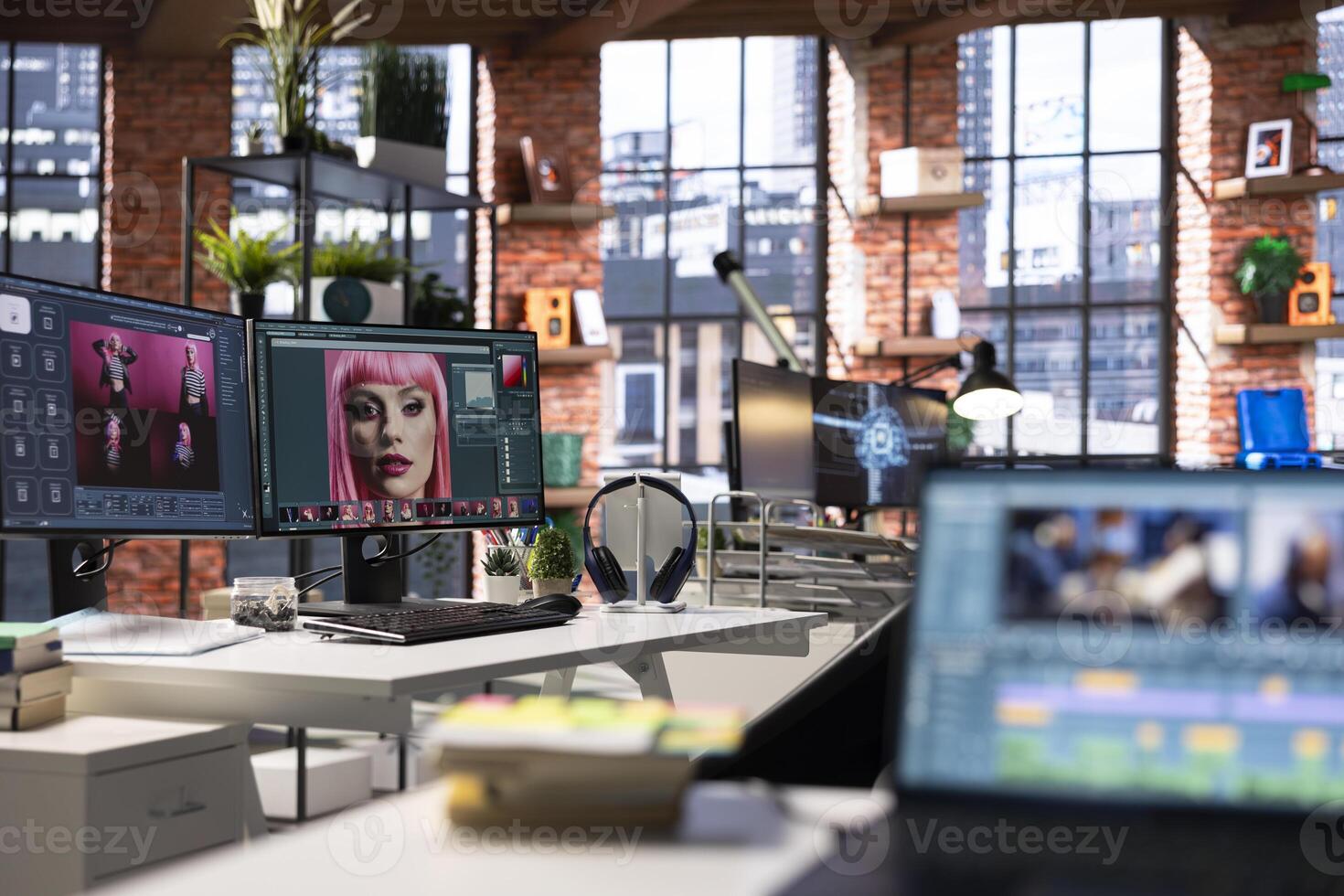 Empty graphic design studio with photo editing setup and AI chat software. Monitors display digital retouching software, color correction and enhancement tools for image processing.