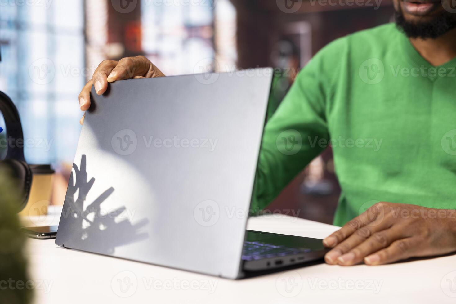 Man in home office opening laptop in the morning, browsing internet, researching information online. Teleworker starting job shift, using search engine on notebook to find data relevant to work tasks photo