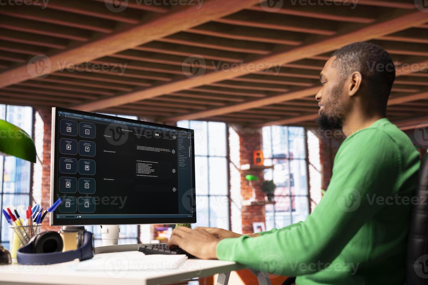 Man at home asks questions to AI LLM chatbot virtual assistant answering user prompts. African american person receiving information from artificial intelligence large language model program on PC photo