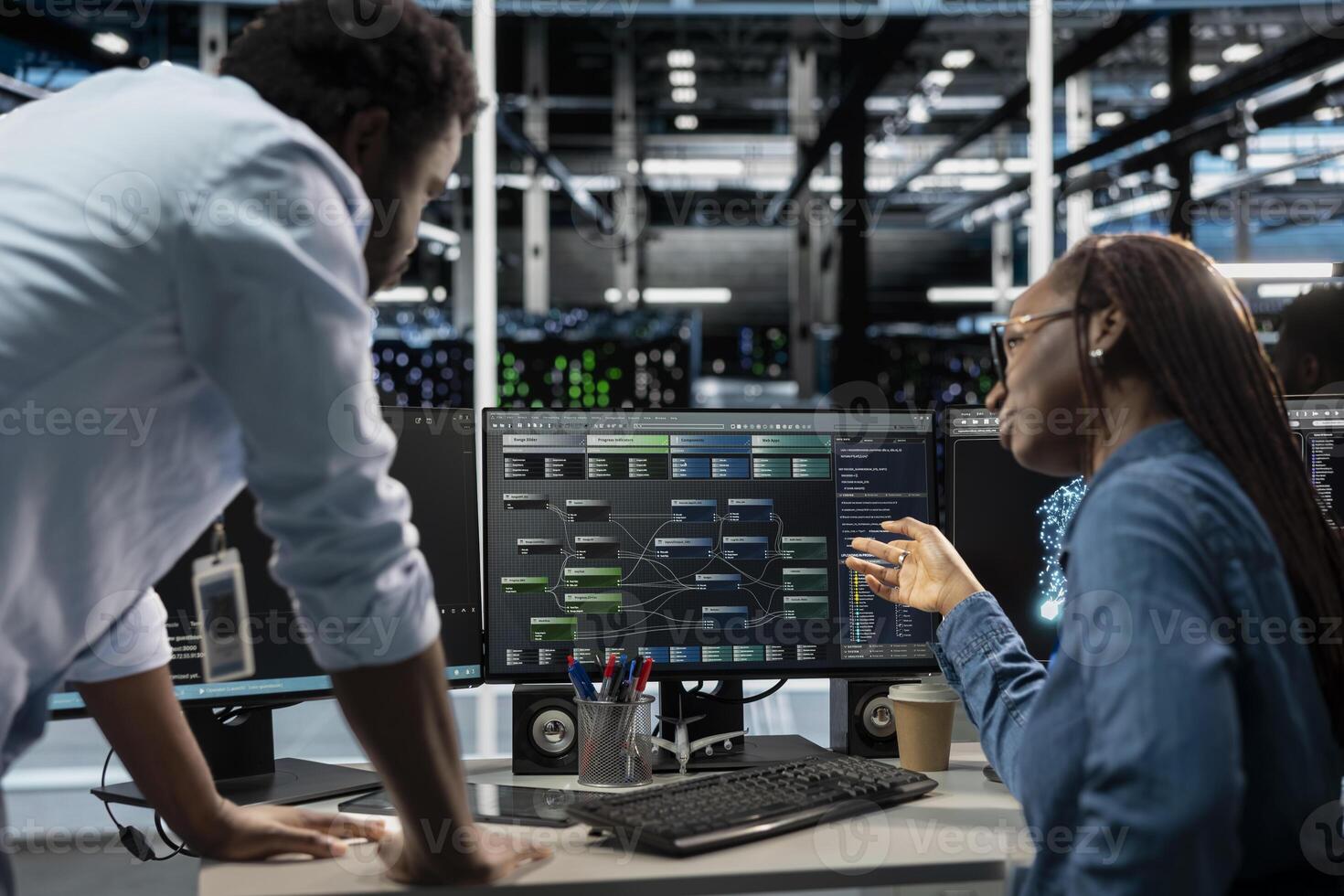 Manager supervising technician programming in server farm housing infrastructure storing datasets. Team leader overseeing IT expert coding, repairing data center racks doing computational operations photo
