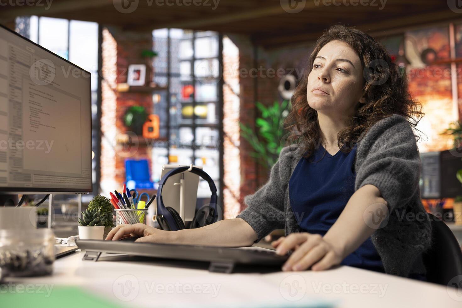 Female programmer developing an app and software algorithm on pc, working at the creative agency. Engineer uses digital tools and focuses on java script engineering and coding, IT specialist. photo