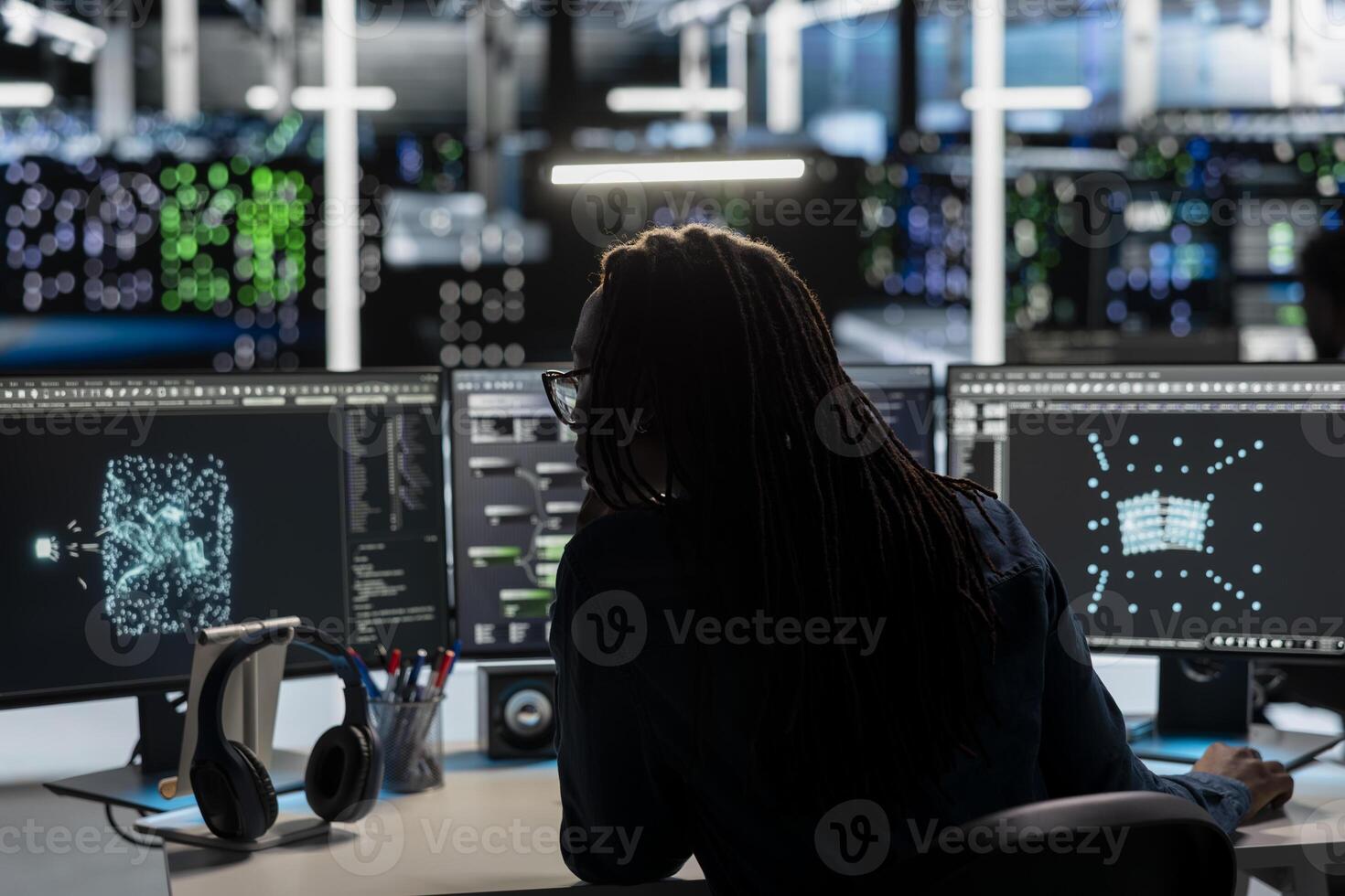 Data center programmer looks at AI visualization dashboard on PC to pinpoint equipment performance issues. Woman in server farm looks at data analysis graph to reduce hardware failures photo