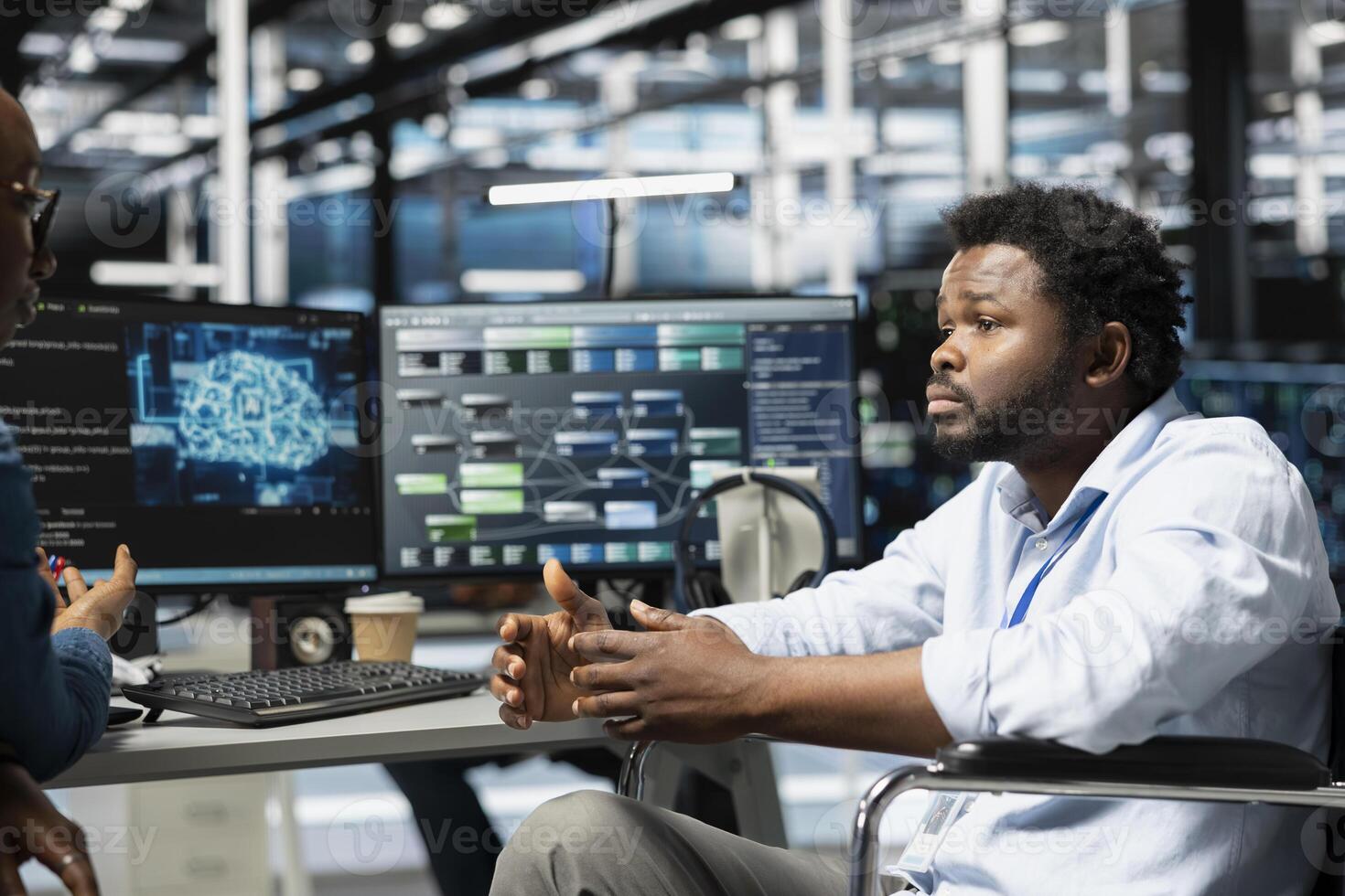 Server hub manager and man in wheelchair use artificial intelligence to perform computing tasks. Engineer with paraplegia and coworker in inclusive data center use AI for machine learning workloads photo