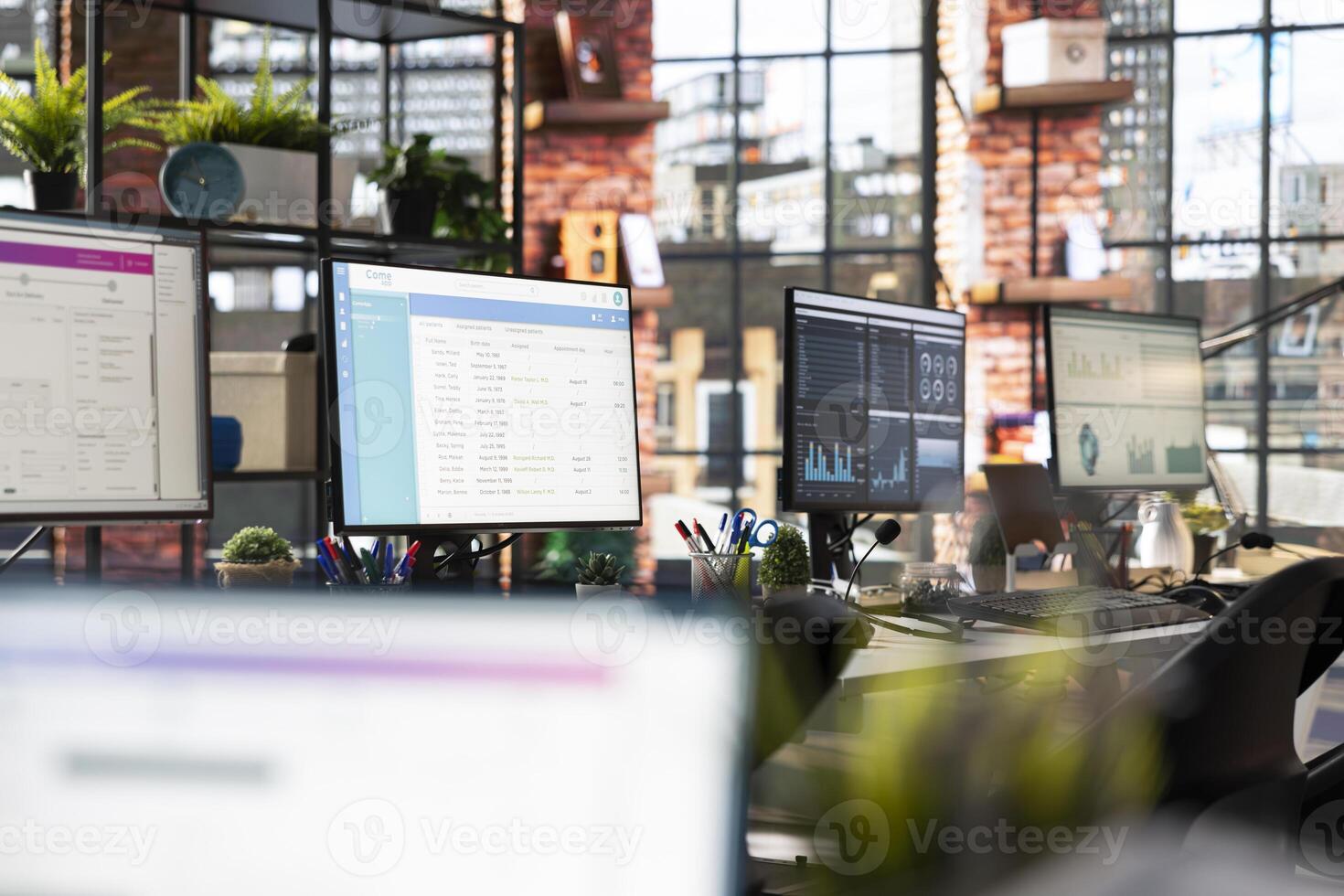 CSM system interfaces on computer monitors in empty customer service workplace used for logging customer interactions. Customer service management software UI on PC displays in call center photo