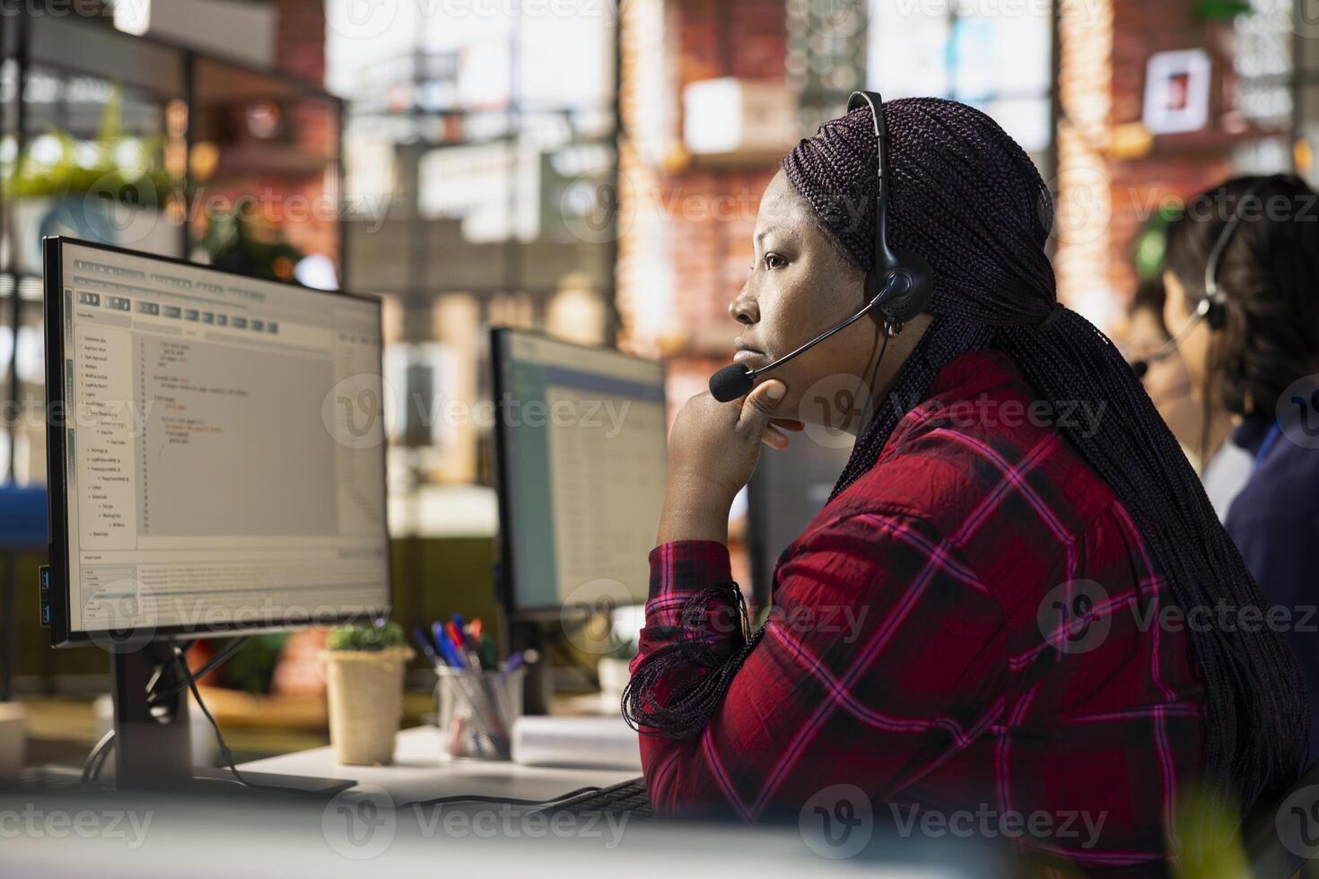 Call center IT specialist helping client, debugging code issues at computer. African american customer support staff member assisting users with troubleshooting and resolving programming errors photo