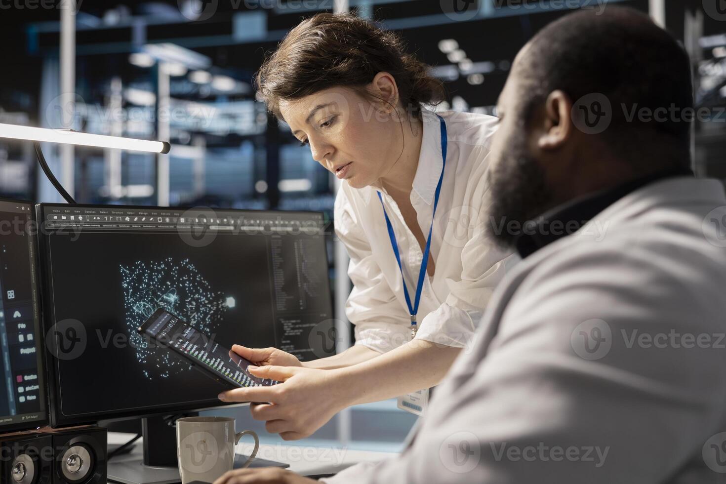 Data center engineers collaborating, doing brainstorming, analyzing software logs to optimize storage systems. Server farm teamworking colleagues inspecting resource utilization on device photo