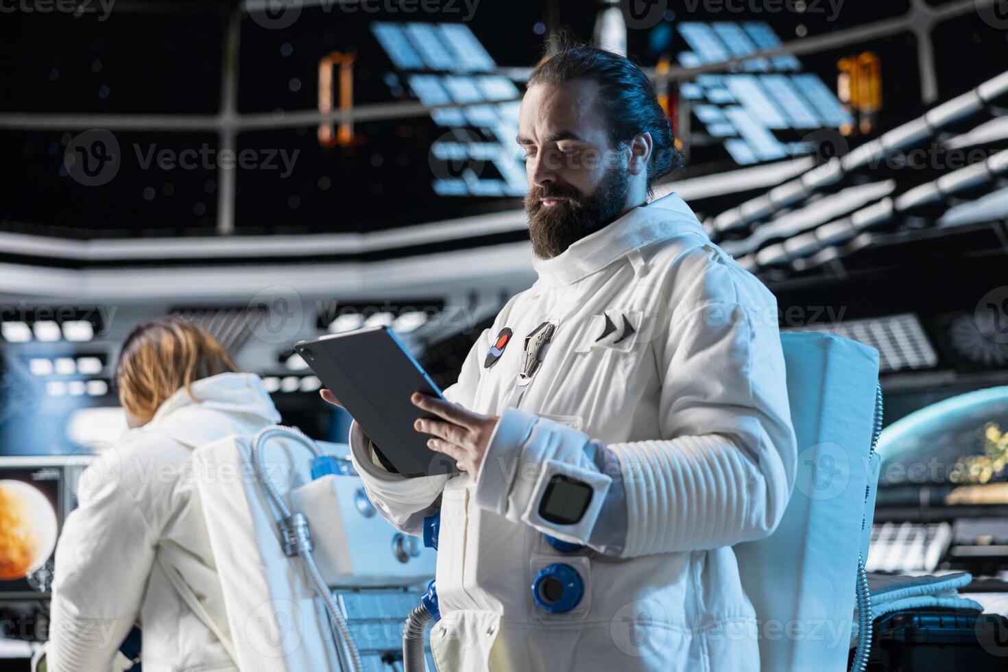 Astronaut wearing spacesuit inside futuristic spacecraft monitoring mission data on tablet screen. Spaceman wearing equipment helmet prepares for space travel operations, reading data on device photo