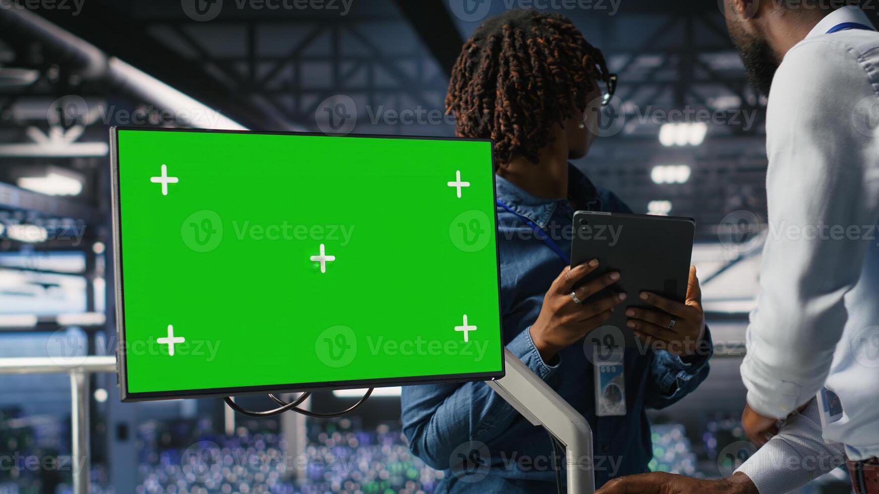 Data center colleagues working on green screen PC, updating storage infrastructure. IT engineering team using mockup computer in server hub workspace filled with networking tech photo