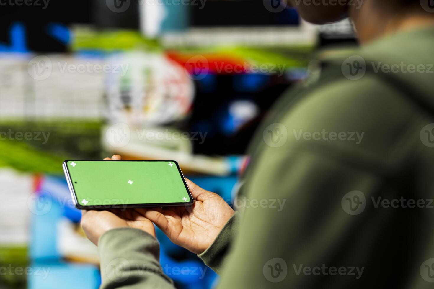 Close up of woman using isolated screen smartphone to enjoy leisure time with content on streaming services. Person watches VOD broadcast on chroma key device in front of digital backdrop photo