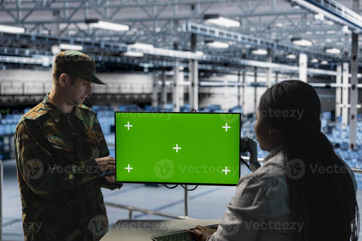 Teamworking soldiers in server hub doing brainstorming, checking reports on green screen display. Team of army information experts working together, monitoring systems using chroma key monitor photo