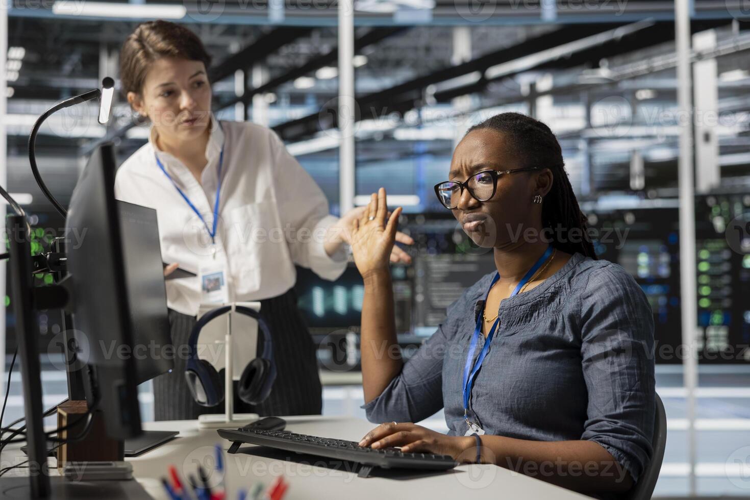 Data center employee being dismissive of manager berating her, reproaching performance issues. Rude technician in server hub ignoring verbal reprimand from irked team leader photo