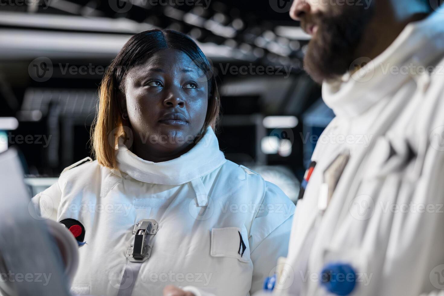 Close up of astronauts in spacecraft using laptop to track stars and asteroids patterns Spaceship crew in spacesuits analyzing mission logs on notebook during planetary exploration photo
