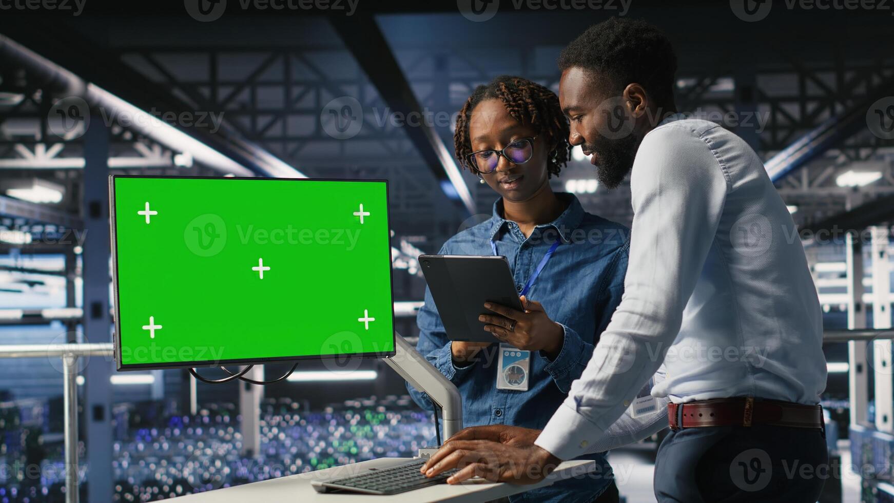 Data center engineering team coding on green screen PC, monitoring AI systems. Server hub IT coworkers use mockup computer to oversee rackmounts powering deep learning processes photo