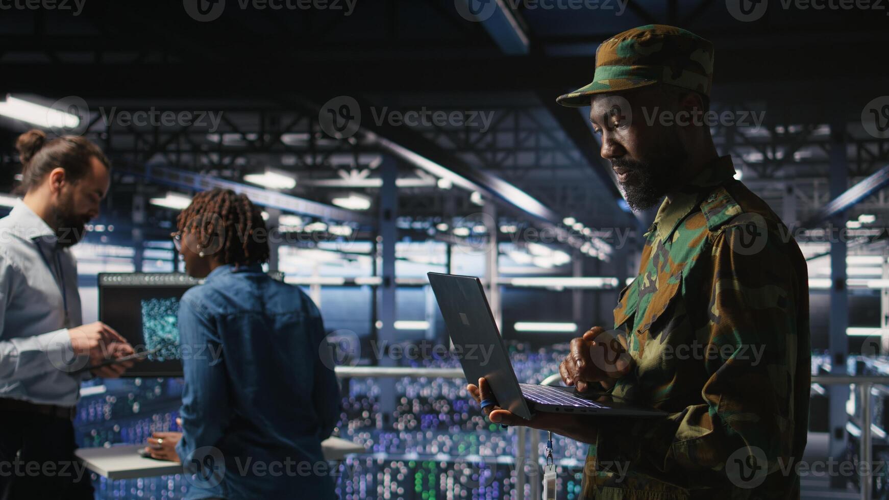 Army IT specialist in data center using laptop to defend networks against cyber threats. Military command center admin using notebook to identify potential intrusions or malicious activities, photo