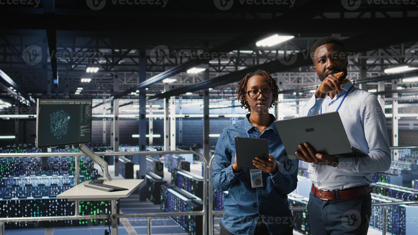 Data center admins running diagnostics on equipment using system monitoring tools to identify errors, doing brainstorming. IT experts work together to prevent failure and minimize downtime, photo