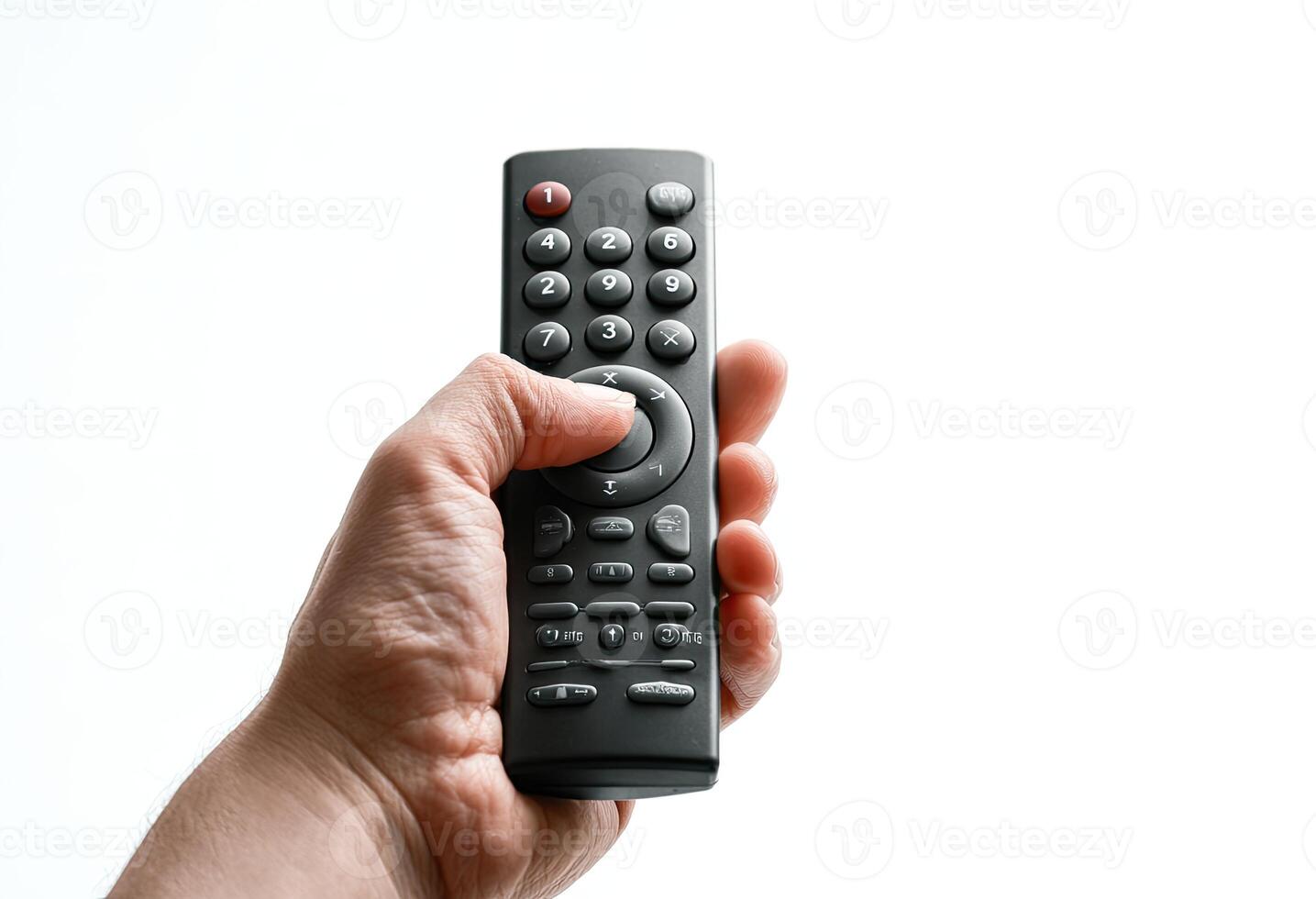 A hand holds a remote control, pressing a button, on a white background photo