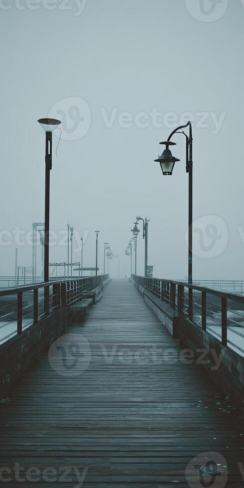 A misty pier extends into the distance, lined with lampposts, creating a moody and atmospheric scene photo