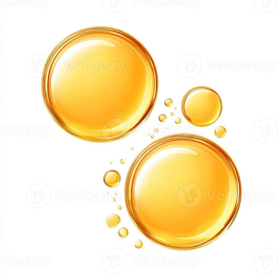 Two large, golden-yellow liquid droplets, or oil bubbles, with smaller bubbles around them, against a white background. The larger droplets are smooth and reflective, with a slightly textured appearance photo