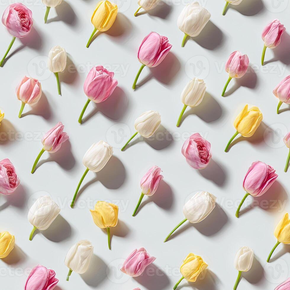 Overhead shot of many tulips in various colors forming a repeating pattern on light background photo