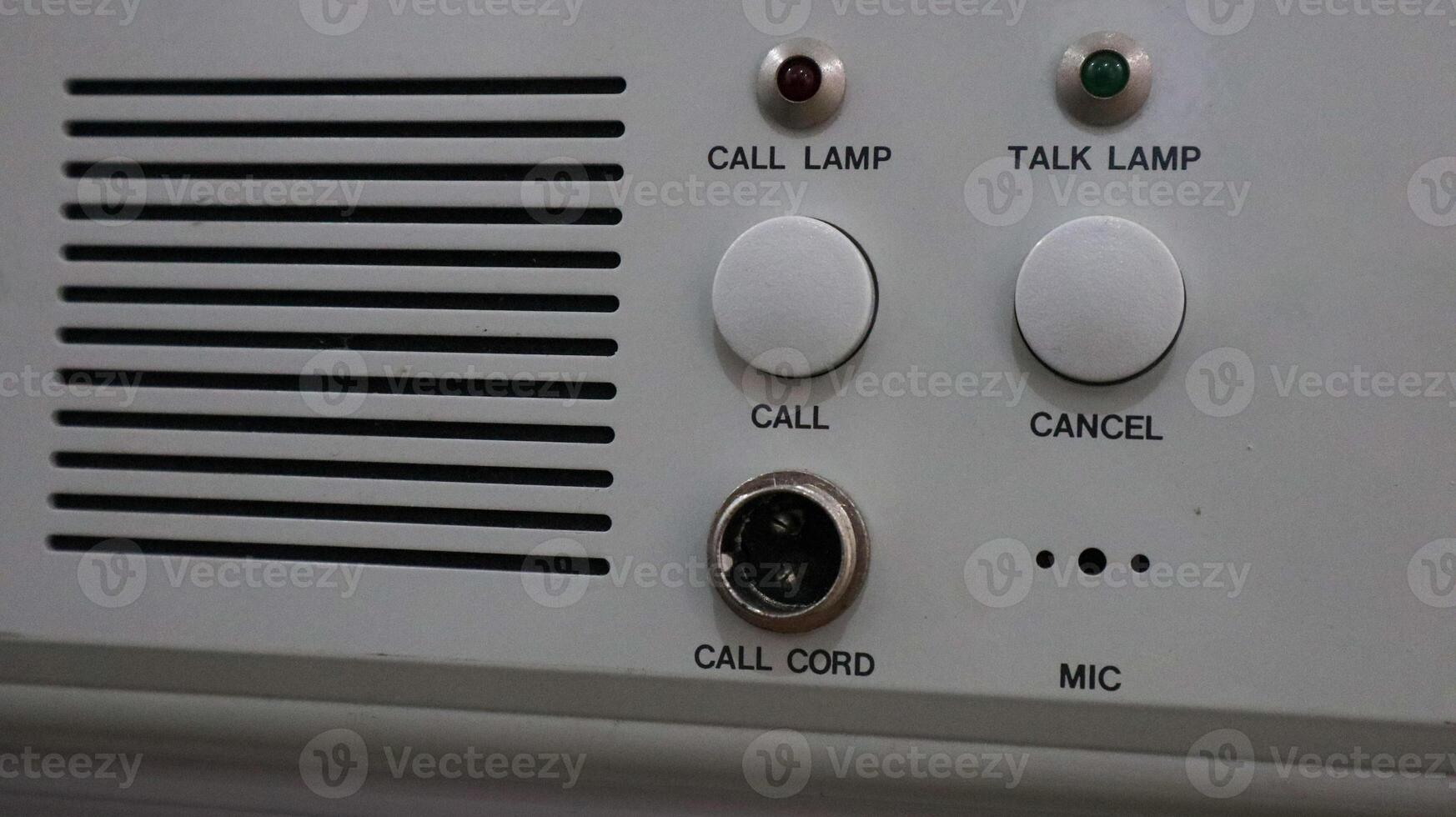 Close-up of an intercom panel with buttons, lamps, and cord connection port photo