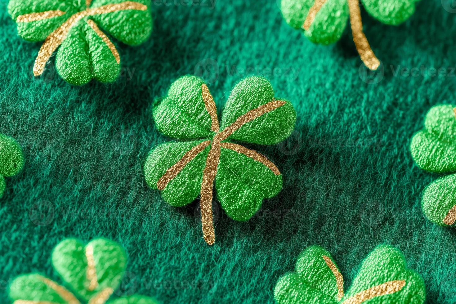 Close-up of embroidered four-leaf clovers with gold accents on a textured green fabric background. The pattern features multiple clovers arranged in a repeating design. photo