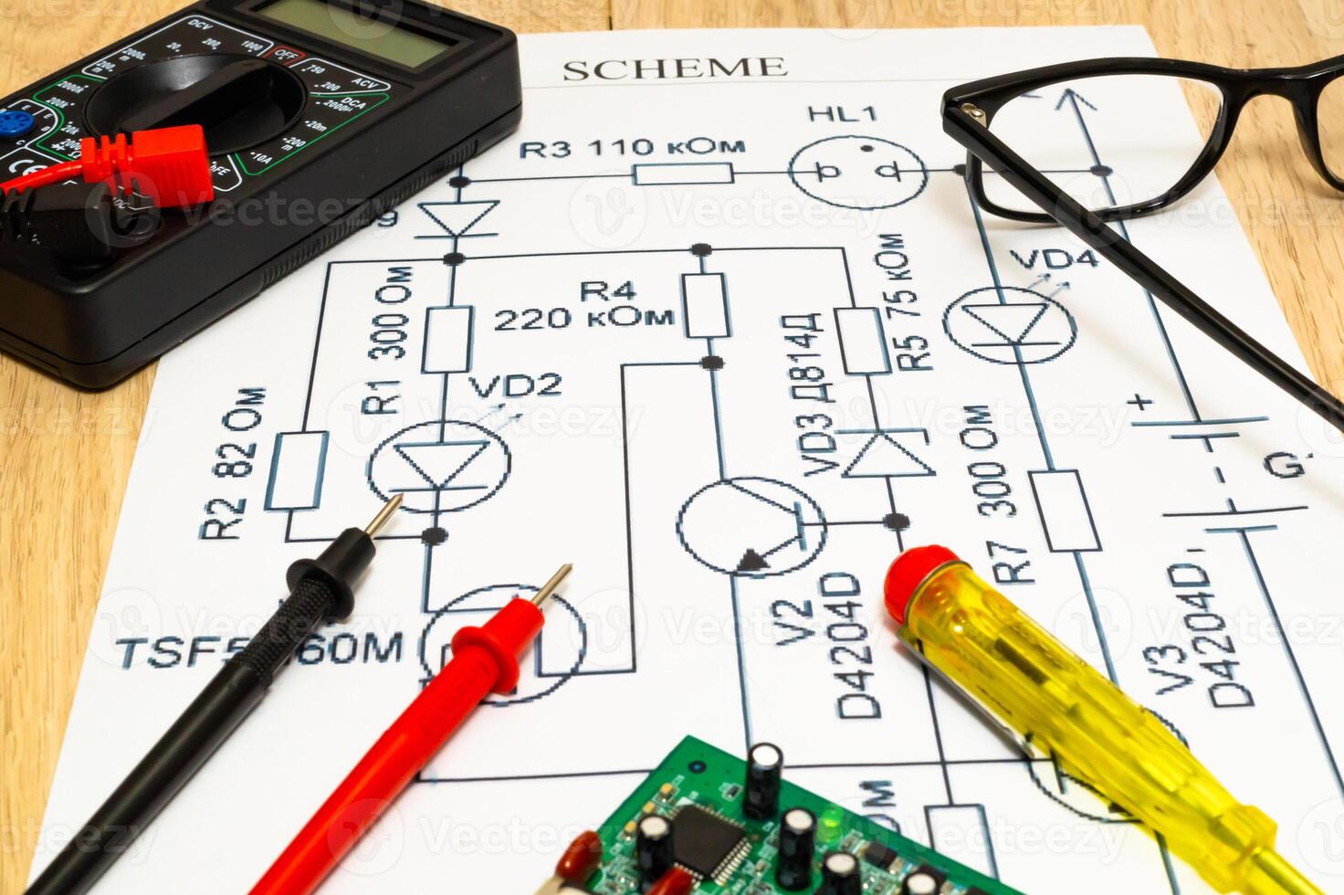 Multimeter probes examining a computer circuit board and circuit. photo