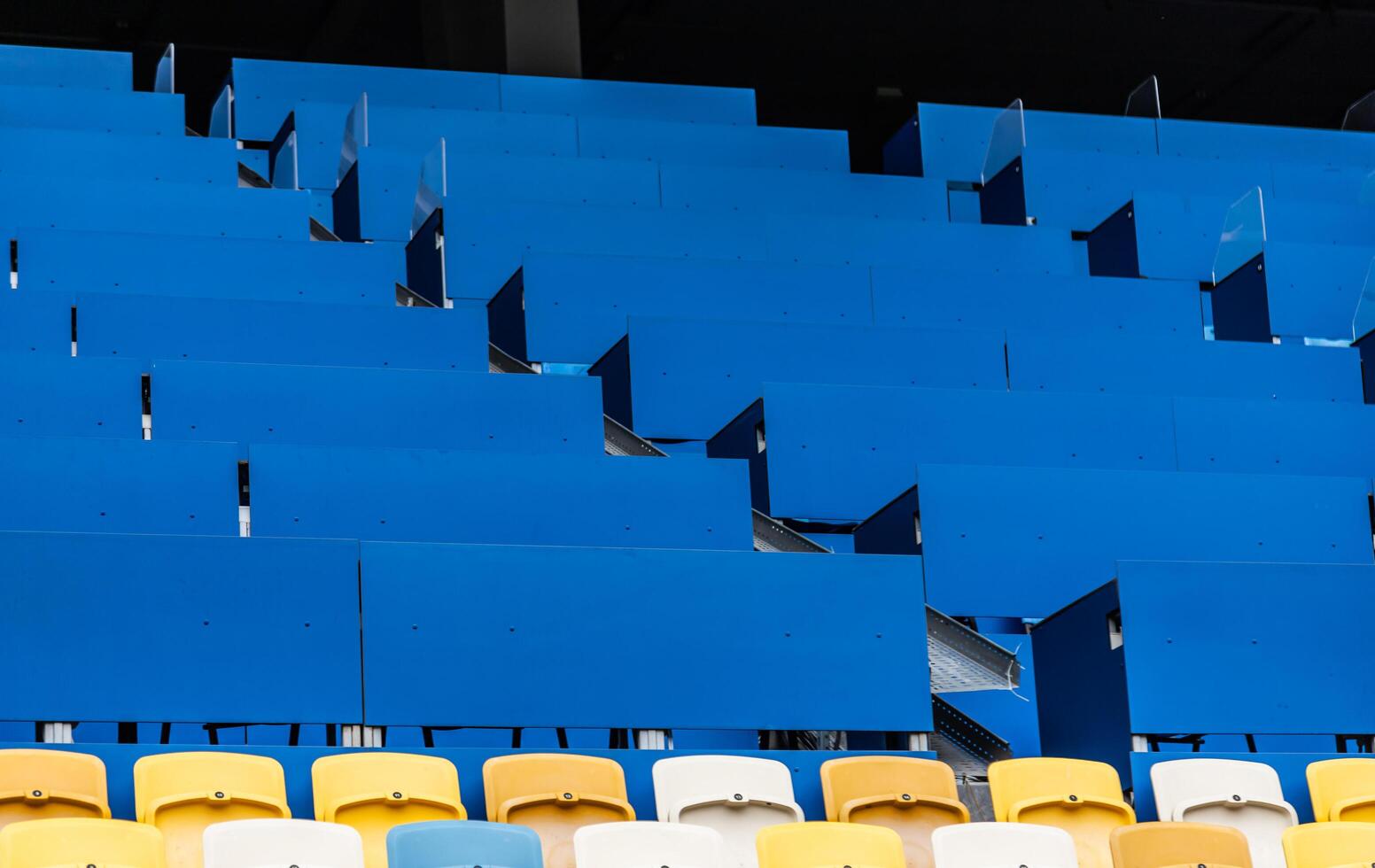 Clean, empty stadium chairs in a defined, colorful sequence along the spectator section photo