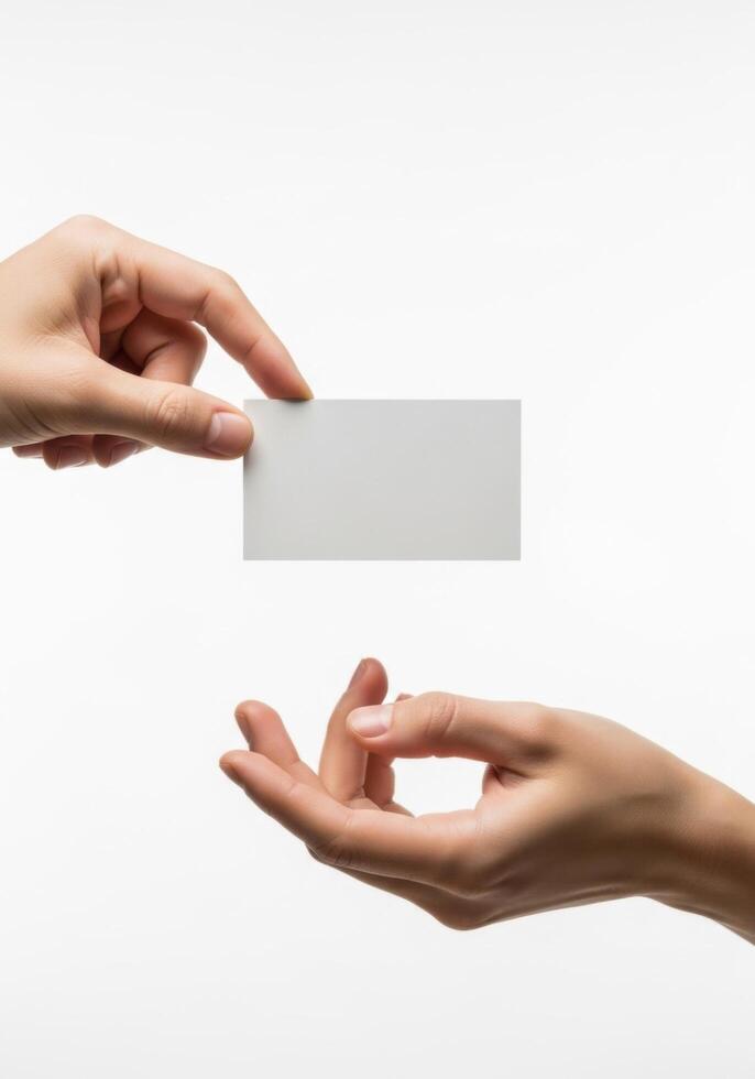 Two hands in the act of exchanging a blank business card, symbolizing networking and corporate introduction on a clean white background photo