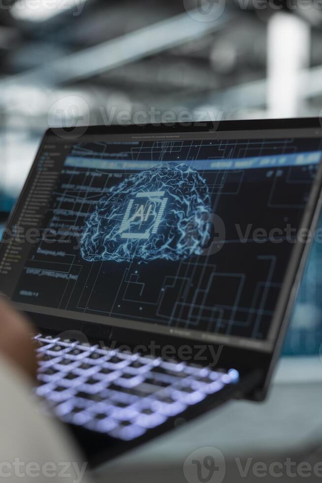 Close up of data center software developer using artificial intelligence computerized model on laptop to oversee operations. Server room IT expert working with AI neural networks algorithms on device photo