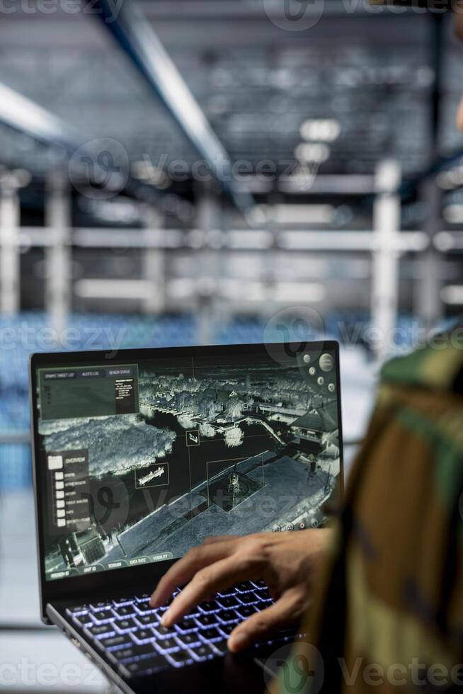 Close up of army expert in data center supporting mission operations with aerial surveillance tools. Military man in server room checking ballistic missiles movement on reconnaissance feed photo