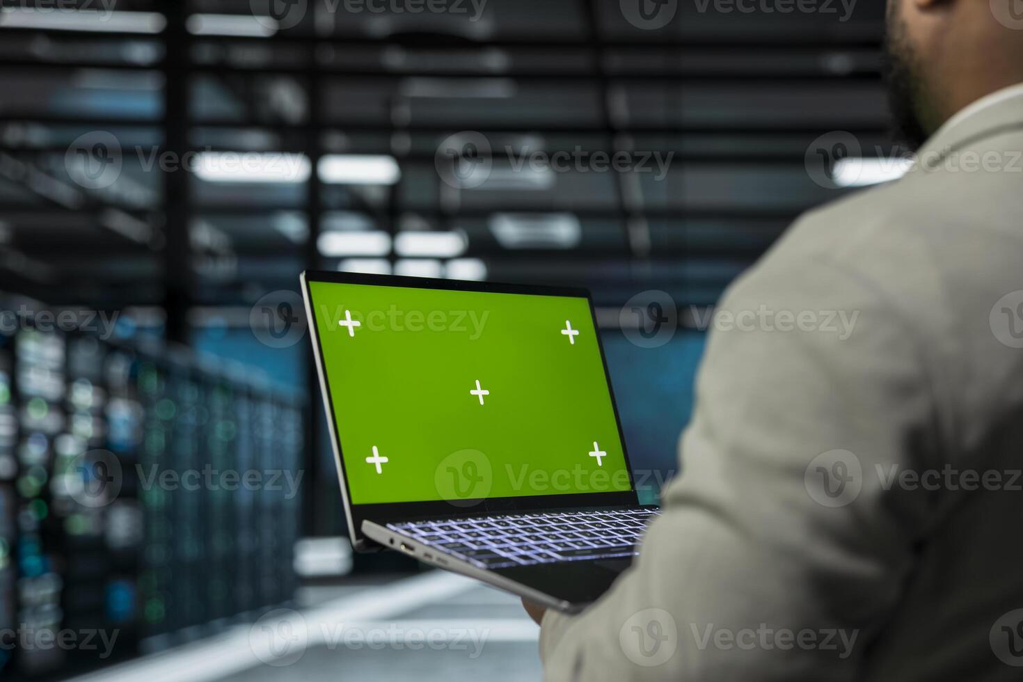 Close up of system administrator in data center using green screen laptop to check for server performance issues. IT expert in server farm fixing errors slowing down hardware using mockup notebook photo
