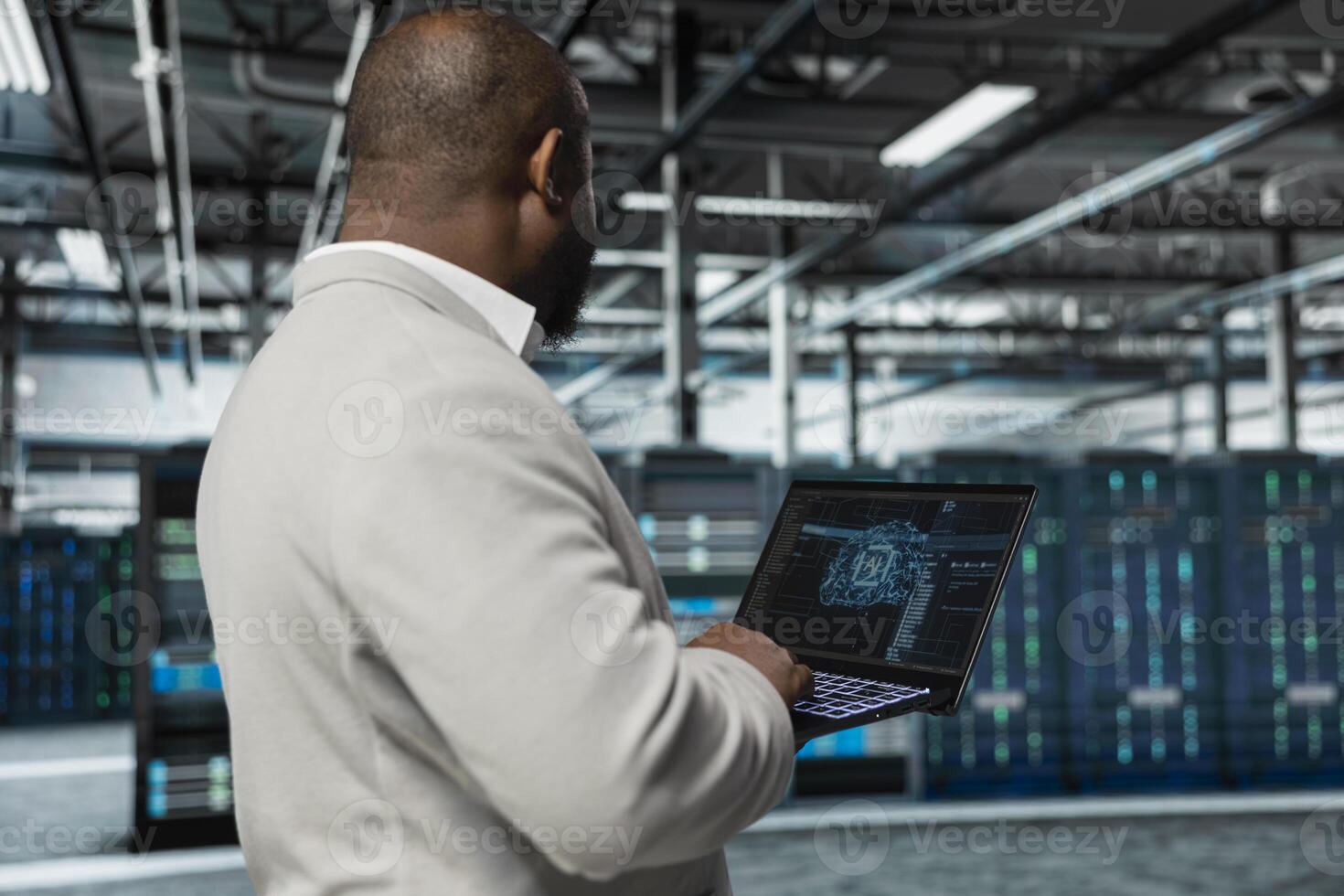 Man typing on laptop in server hub, monitoring data center energy consumption using AI software. Engineer managing supercomputers in server farm using artificial intelligence tech photo