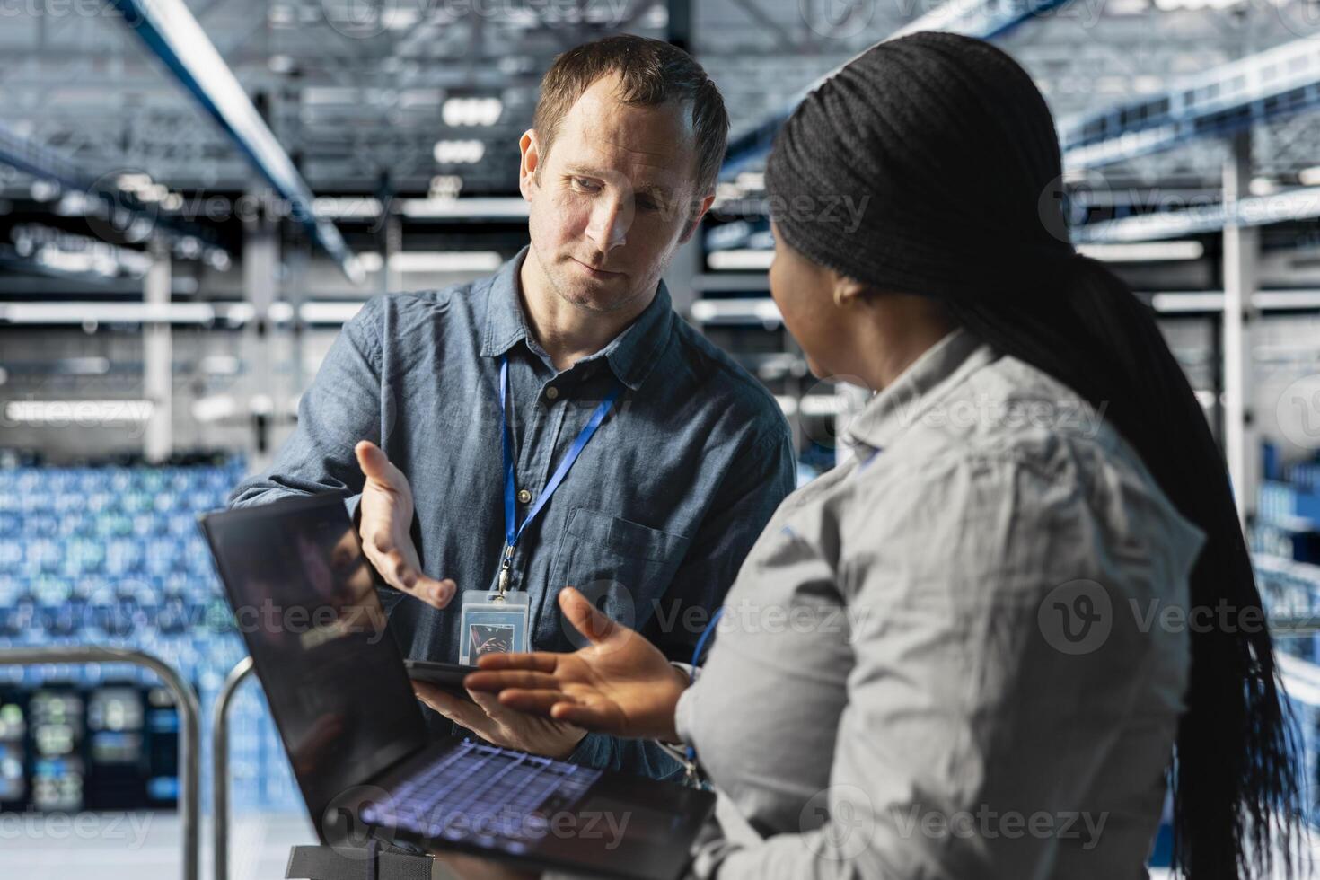 Server hub colleagues doing brainstorming to fix spyware injected by hacker stealing sensitive data. Data center cybersecurity experts working together to contain network breach photo