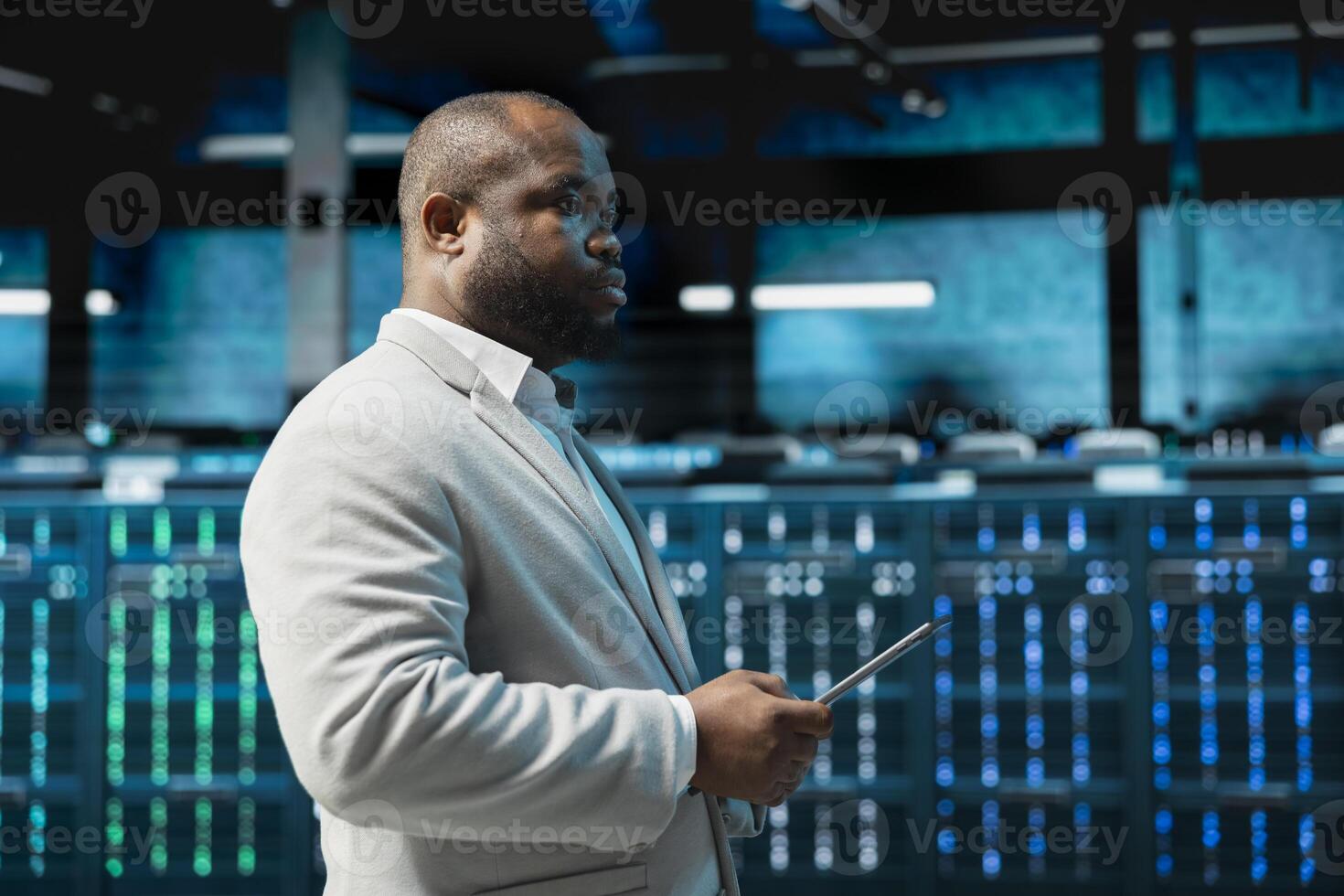 Data center admin monitoring thermal levels using tablet, doing checkup to prolong hardware life span. Server hub worker monitoring infrastructure rigs, reviewing configurations photo