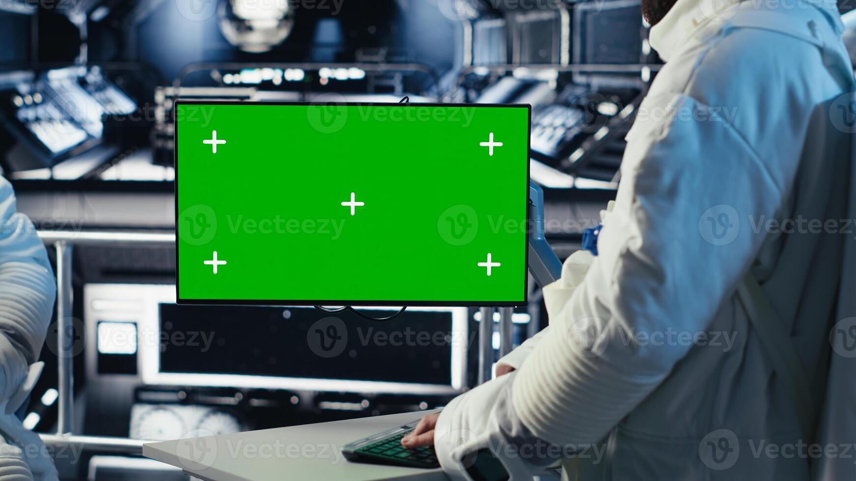 Astronaut monitoring system diagnostics on green screen display, talking to colleague during space mission. Teamworking cosmonauts using chroma key monitor during mankind survival expedition photo