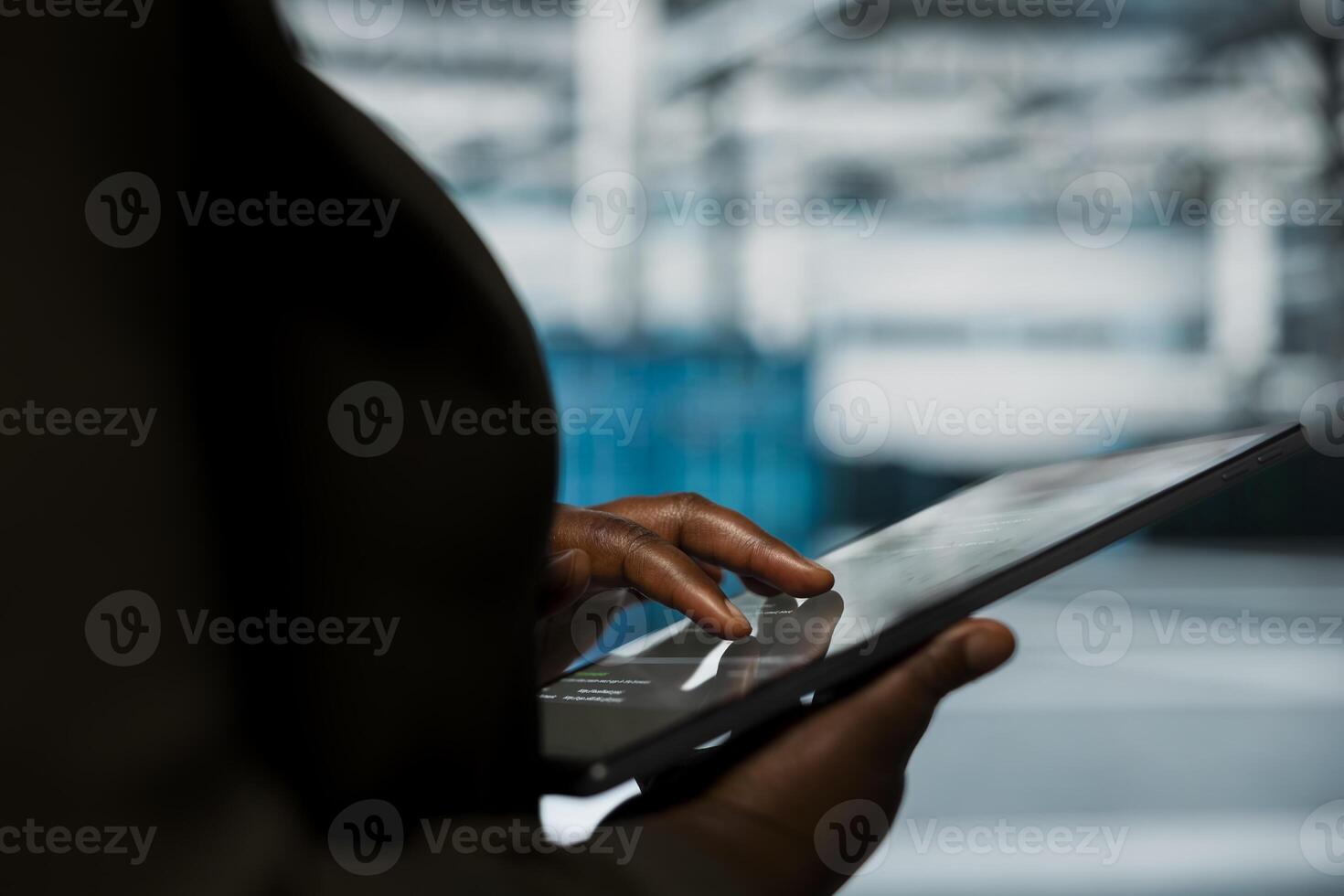 Close up of engineer using tablet in data center to track metrics of gear used to host websites. Server room employee upgrading capacity of storage rackmounts running companies databases photo