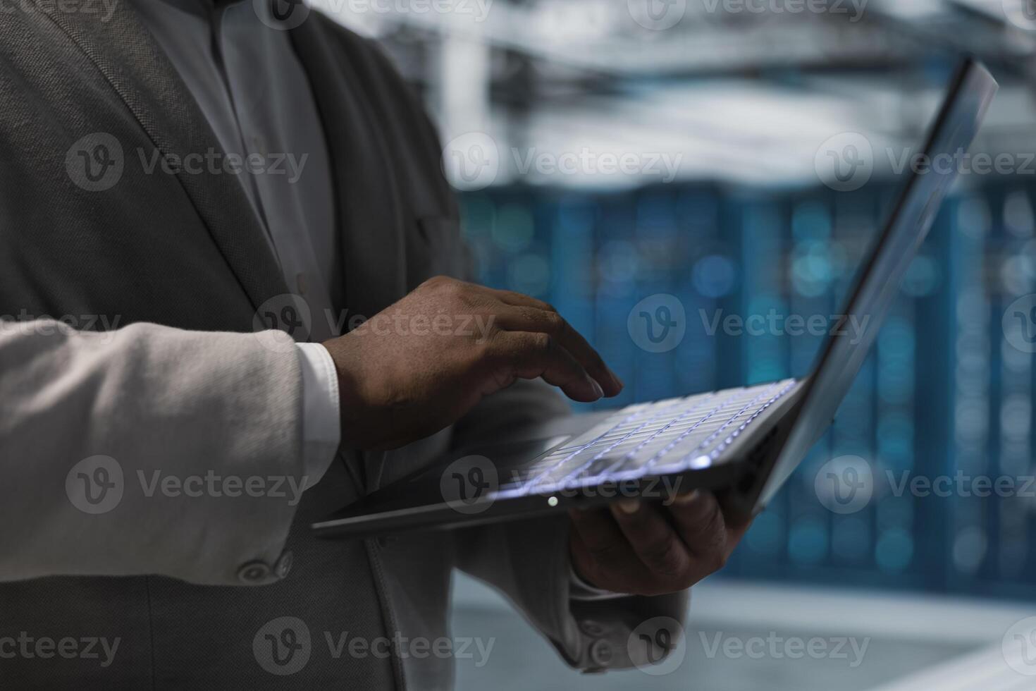 Close up of high tech server farm admin managing equipment systems, checking recovery plan. Data center IT professional monitoring performance, making sure supercomputers are functioning optimally photo