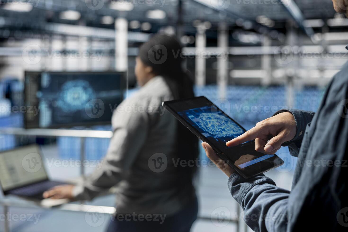 Close up of computer scientist in server hub using tablet to enhance AI model accuracy. Data center software developer using device to schedule maintenance for AI hardware rigs photo