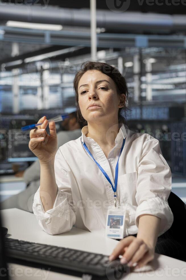 Technician in server room using PC to implement and manage data backup solutions. Data center engineer identifying and resolving technical issues, ensuring efficient recovery photo