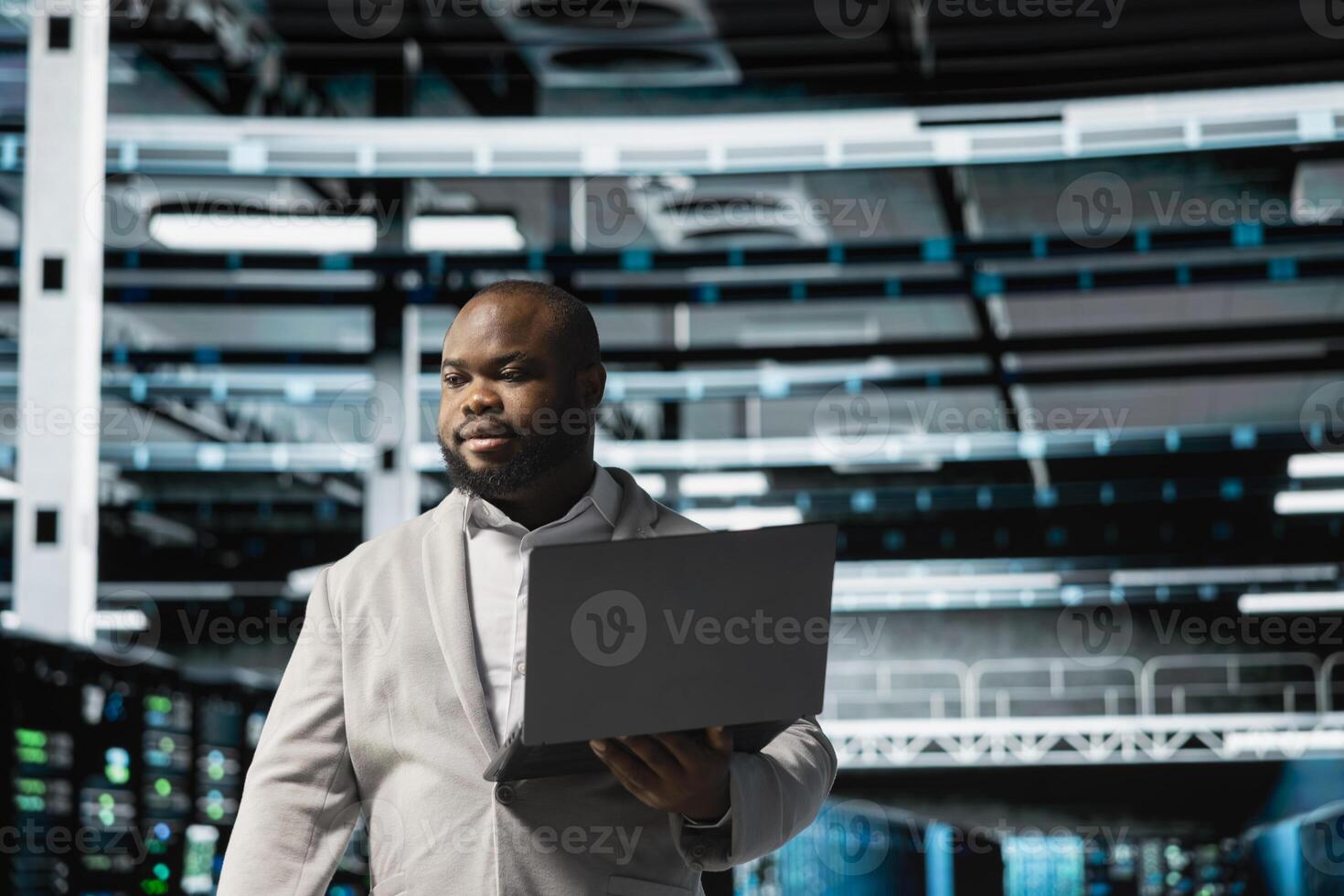 Data center admin using laptop to automate errors detection, troubleshooting backend operations. Server hub IT expert monitoring components for potential failures, conducting regular security audits photo