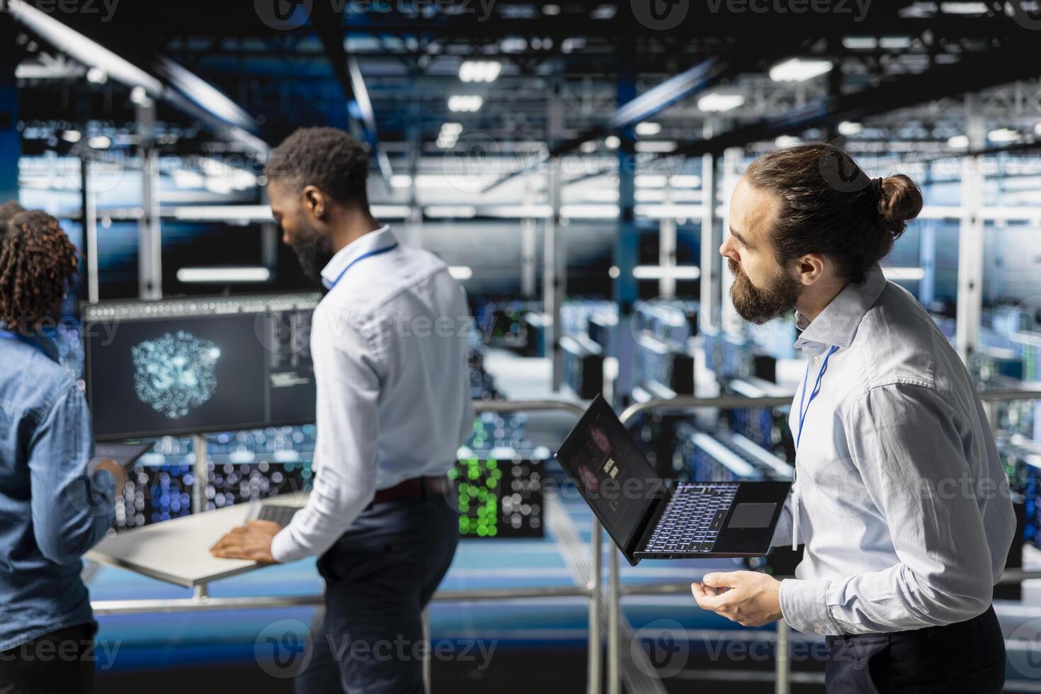 Worried technician in server room detecting hacking attempt targeting data systems and panicking about data breach. Engineering team under pressure by virus activity, emergency protocol. photo