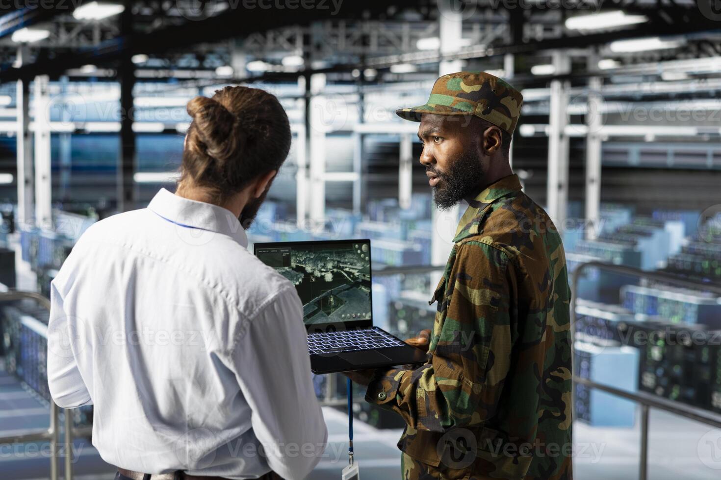 Military operator and IT expert in army data center using AI on laptop to manage autonomous defense systems. Soldier and programmer ensuring strategic threat detection tools for security. photo