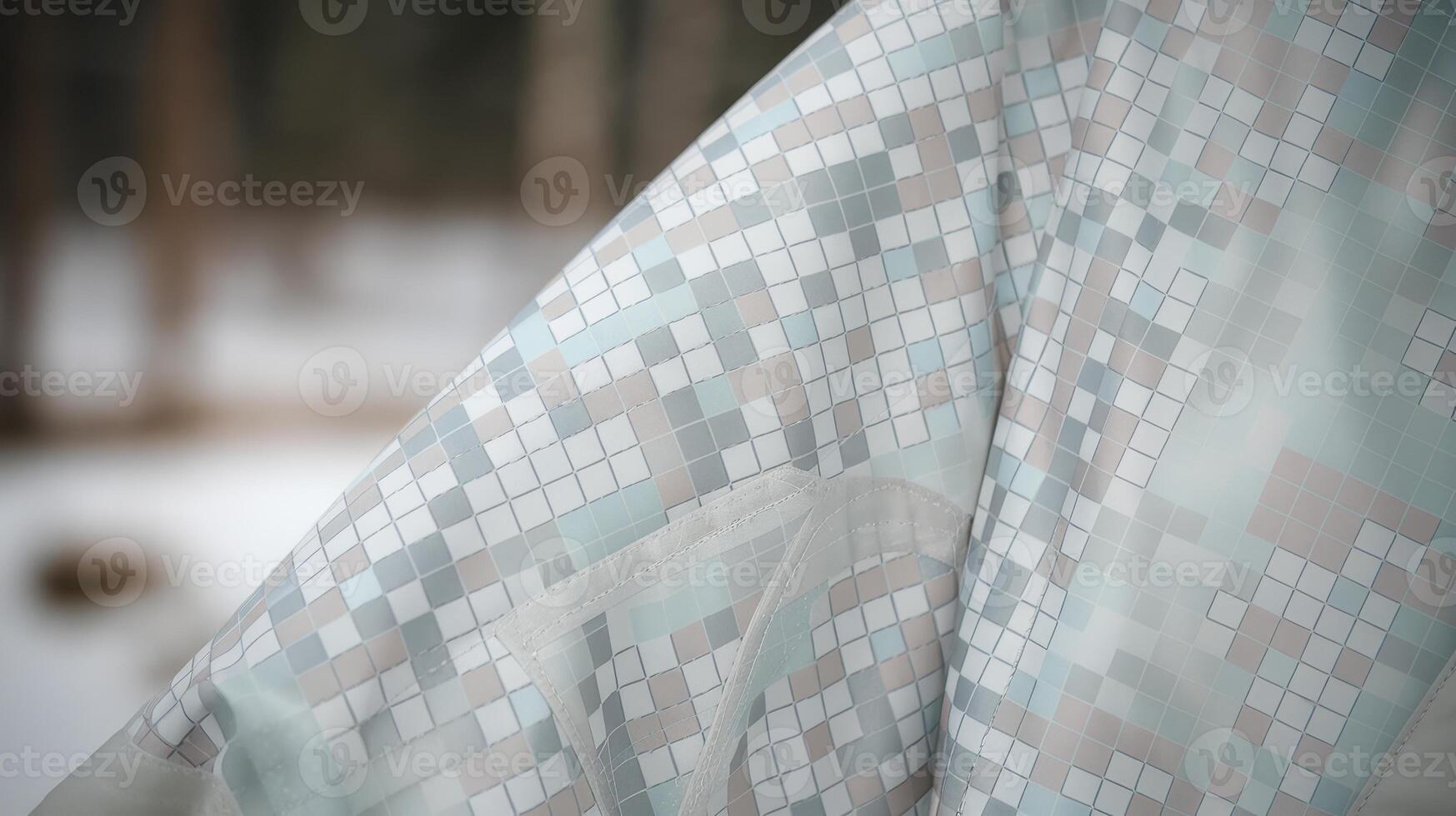 Close up of a Winter Jacket With a Square Mosaic Pattern in a Snowy Forest Environment photo