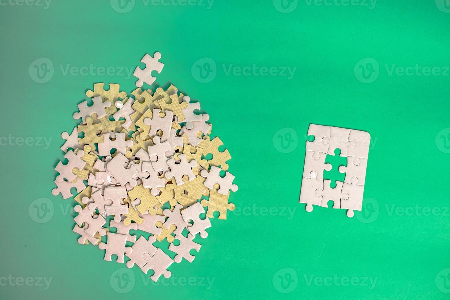 Conceptual puzzle pieces on green background emphasizing problem-solving and creativity photo