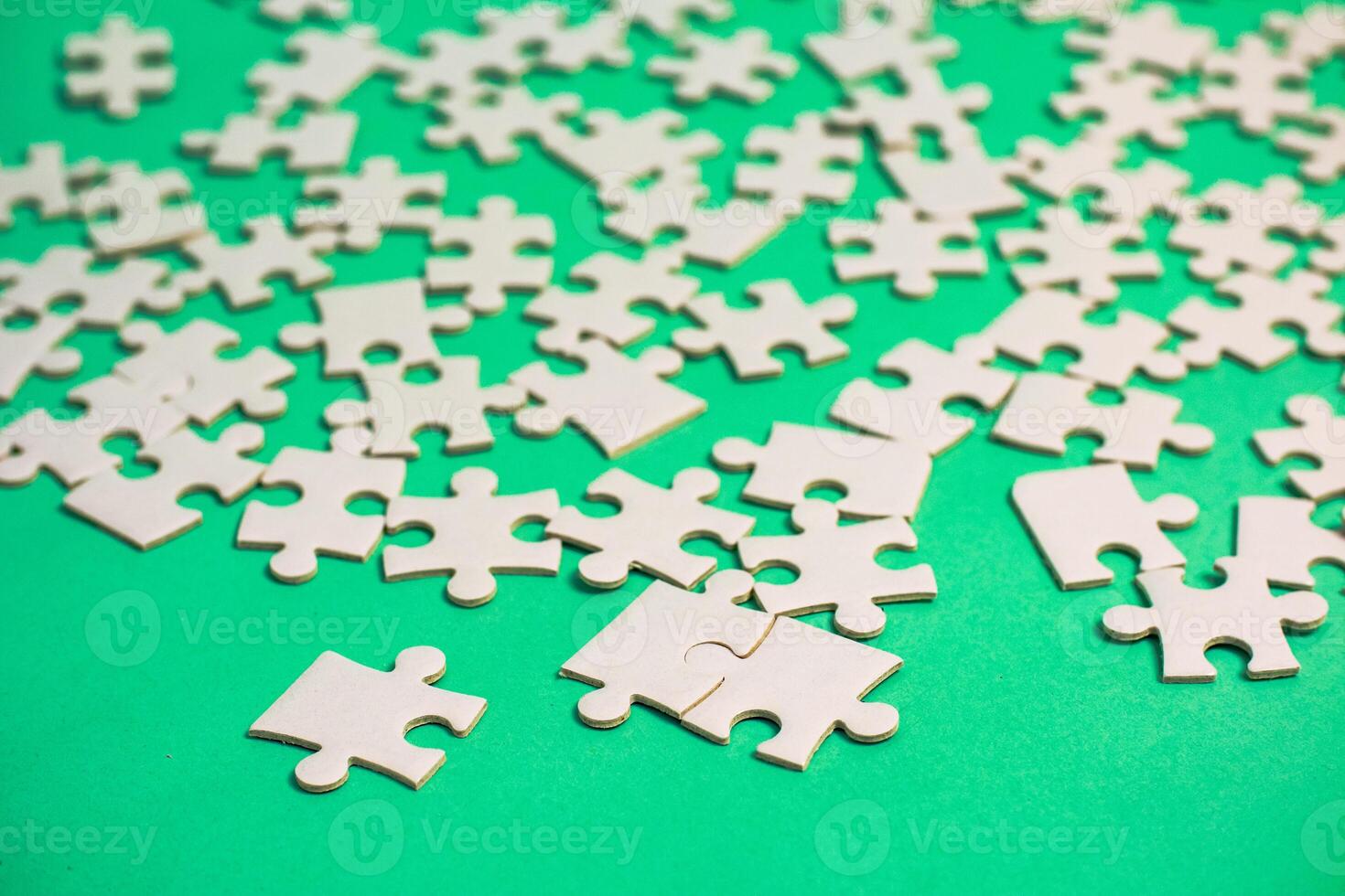 Scattered Puzzle Pieces on a Green Background Suggesting Problem Solving and Strategy photo